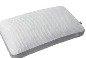 Angled view of the rectangular back sleeper version of the Sleeptone Basics Cooling Pillow, displaying the same white honeycomb texture and grey cooling side panel with a snowflake logo.